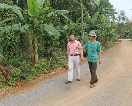 Anh Nguyễn Đức Hảo (bên trái) đi trên con đường do anh hiến một phần đất để xây dựng